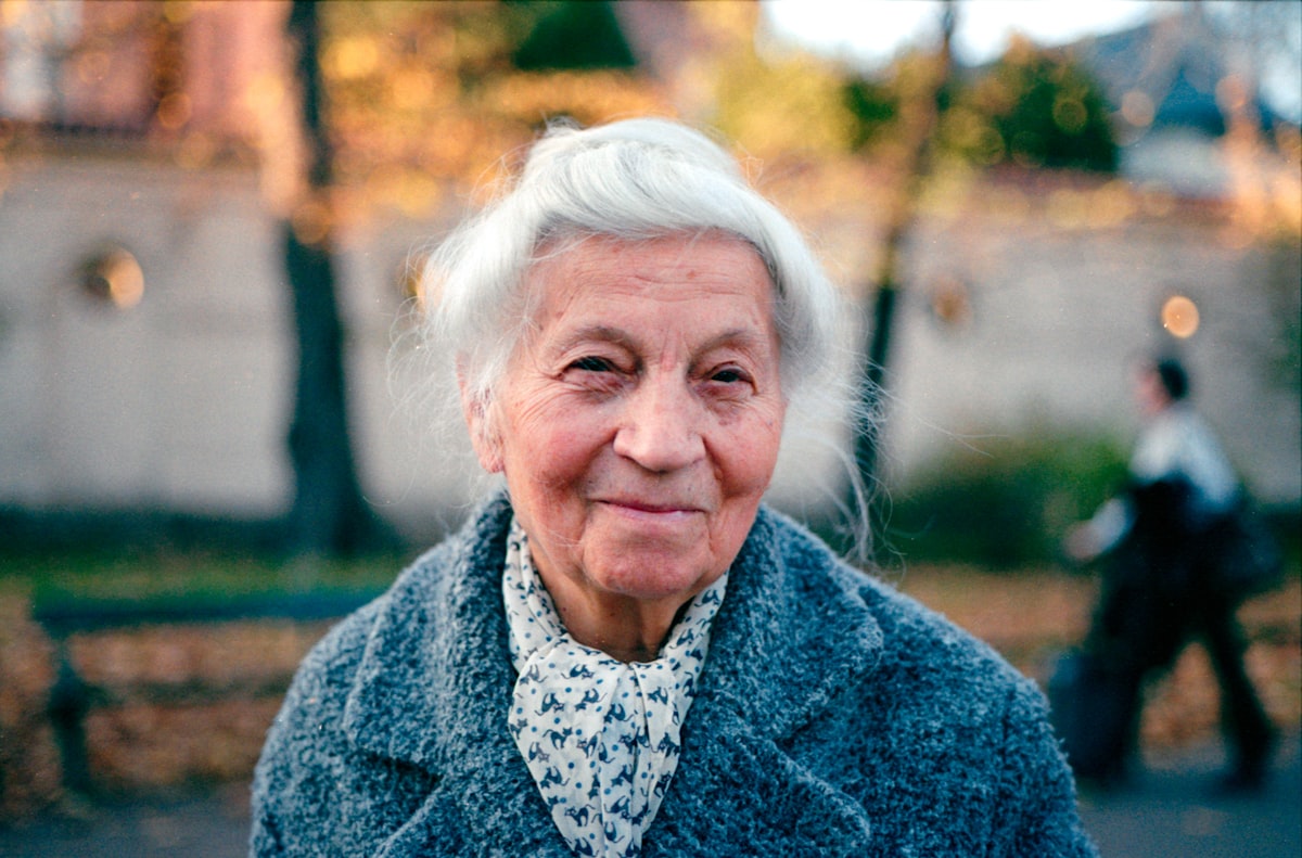Mujer madura sonriendo con productos de vitaminas